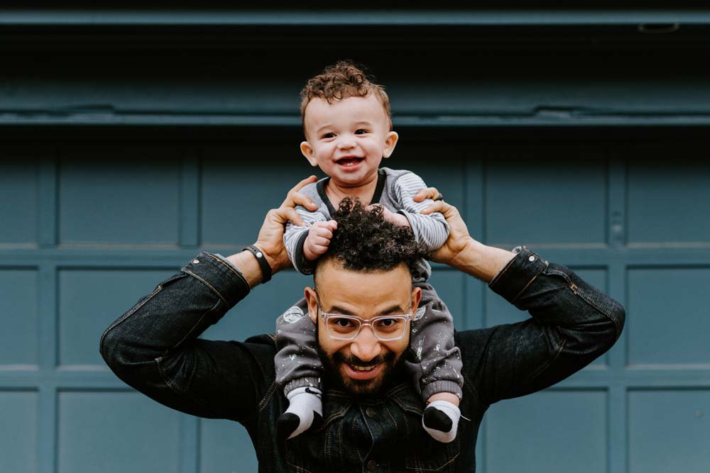 Baby getting a piggy-back ride from his dad